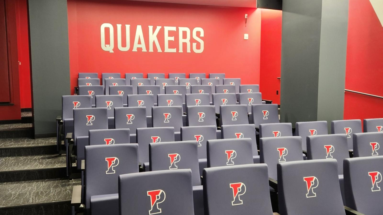 Stadium seating in a small auditorium with Penn logo on chairs 