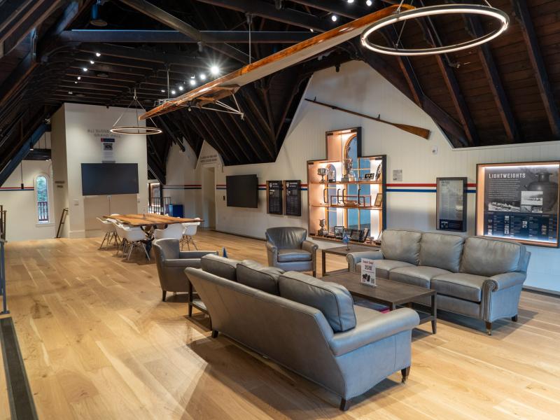 View of renovated boathouse interior with couches, tables, memorabilia 