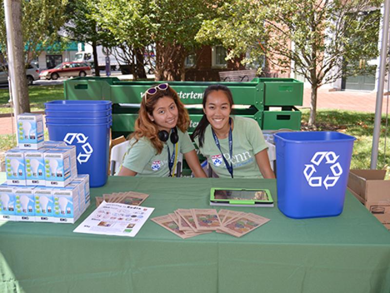 Student volunteers hand out recycling bins and CFLs to new students during Move-In