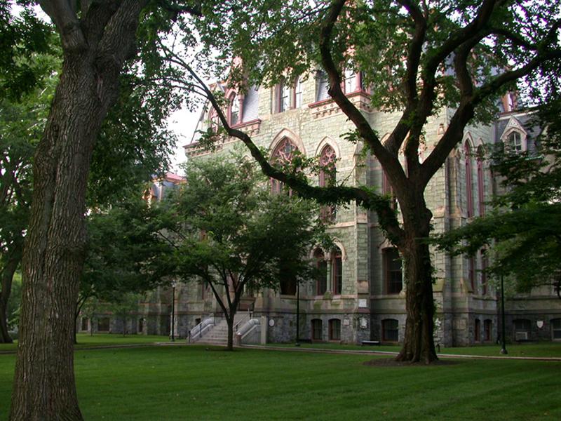 College Hall peeking through brilliant green trees