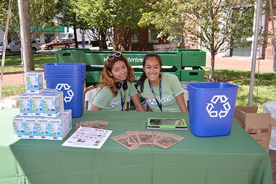 Student volunteers hand out recycling bins and CFLs to new students during Move-In
