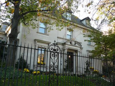 Stone Victorian mansion behind wrought iron gate 