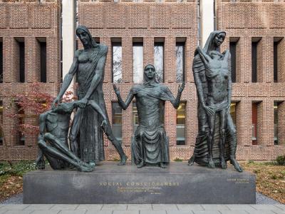 Large statue of three female figures with arms outstretched 