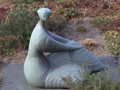 Seated Woman statue surrounded by grass